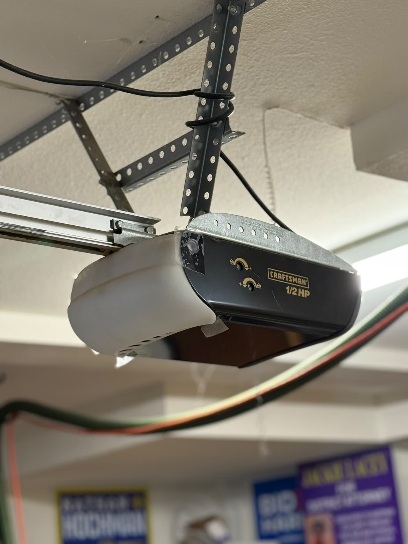 Aging Craftsman garage door opener with cracked light cover, before replacement