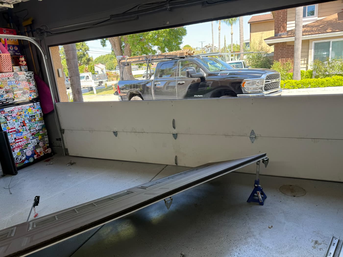 Garage door panel replacement in progress on jack stands