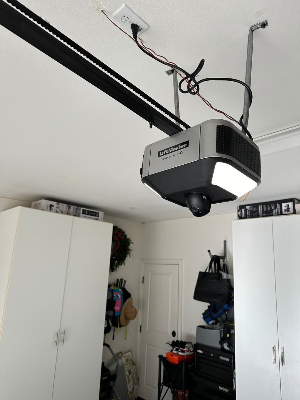 LiftMaster WiFi smart garage door opener with built-in camera, freshly installed on a garage ceiling